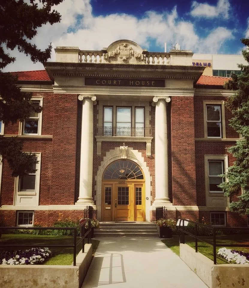The Old Red Deer Court House: red brick, Ionic columns, and COURT HOUSE carved into the limestone frieze.